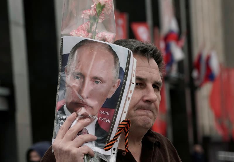 FILE PHOTO: A man demonstrates a portrait of Russian President Vladimir Putin during the celebrations of Victory Day in Moscow