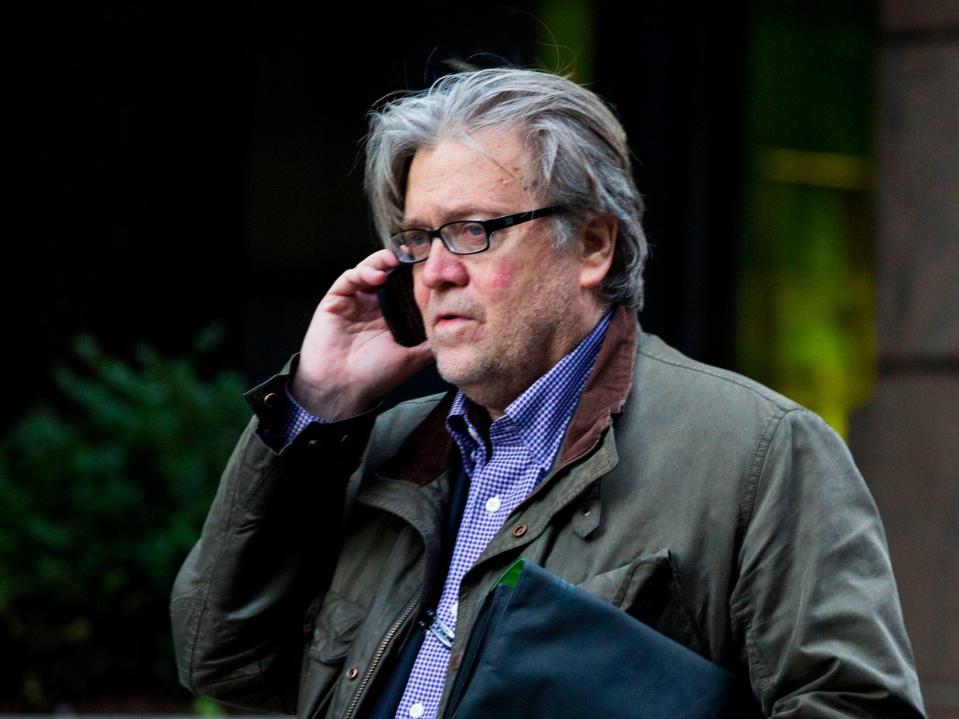 Steve Bannon on the phone wearing a green jacket.