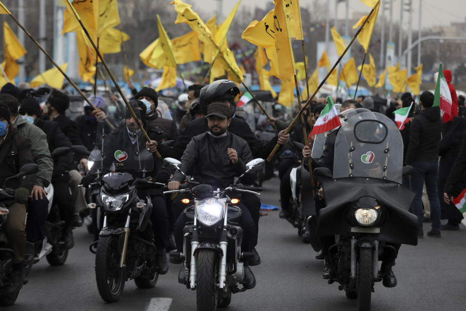 Men on motorcycles attend the annual rally commemorating the anniversary of Iran's 1979 Islamic Revolution at the Azadi (freedom) Square in Tehran, Iran, Friday, Feb. 11, 2022. Thousands of cars and motorbikes paraded in the celebration, although fewer pedestrians were out for a second straight year due to concerns over the coronavirus pandemic. (AP Photo/Vahid Salemi)