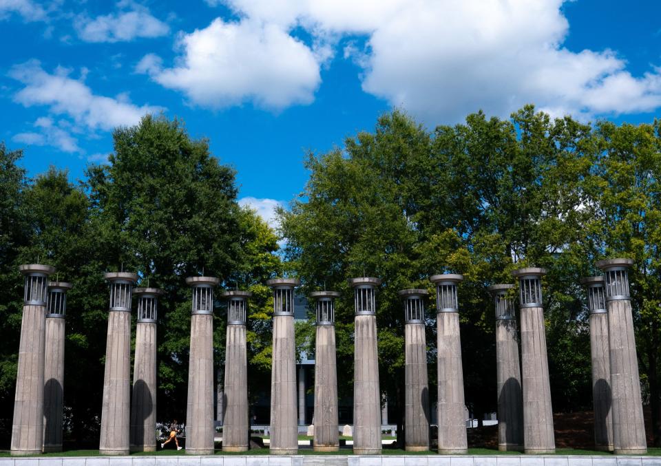 A runner passes by The Court of the Three Stars at the Bicentennial Capitol Mall Tuesday afternoon, Aug. 15, 2023. The Carillon of Bicentennial Mall is comprised of limestone columns with bells tuned to different pitches that play music by native Tennessean musicians and songwriters.