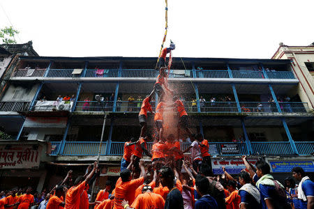 A devotee breaks a clay pot containing curd as others form a human pyramid during celebrations to mark the Hindu festival of Janmashtami in Mumbai, India August 25, 2016. REUTERS/Danish Siddiqui