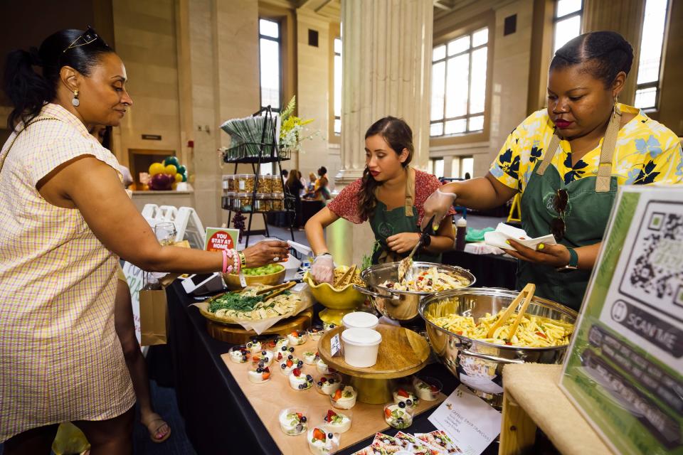 Feast & Graze, from left, Raneisha Myers and Winnie Bradley prepare samples for Mimi Wilson during the Craft Food & Wine Festival at One Commerce Square on Sunday, June 5, 2022.