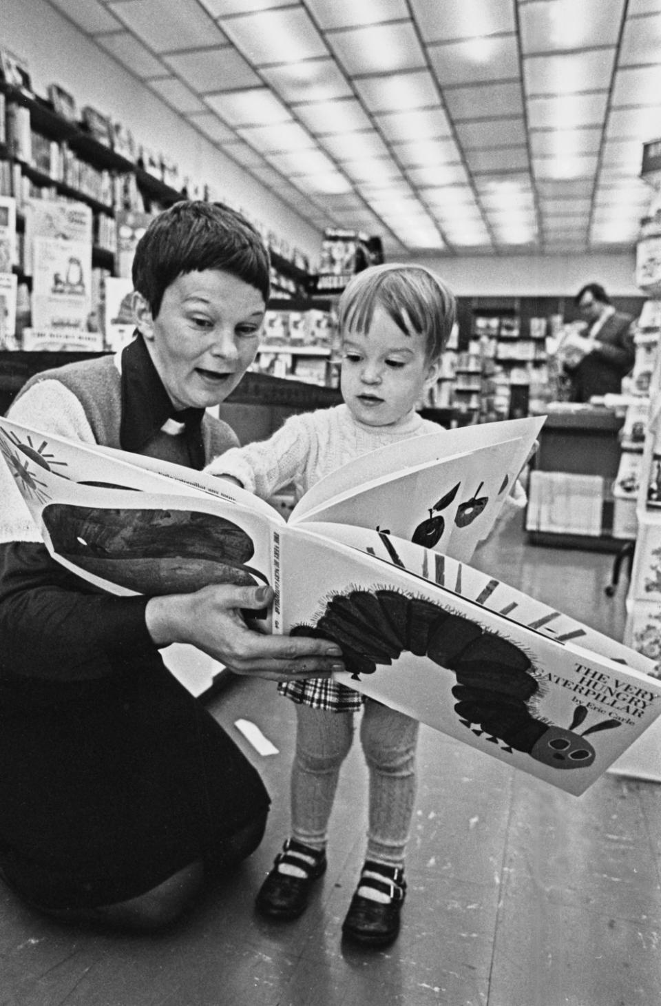 Justine Stehle and Andre Lewis reading the children's book 'The Very Hungry Caterpillar' by Eric Carle