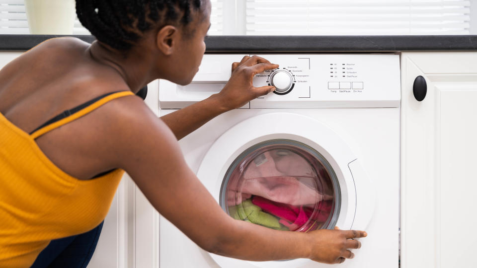 A woman programming a washing machine