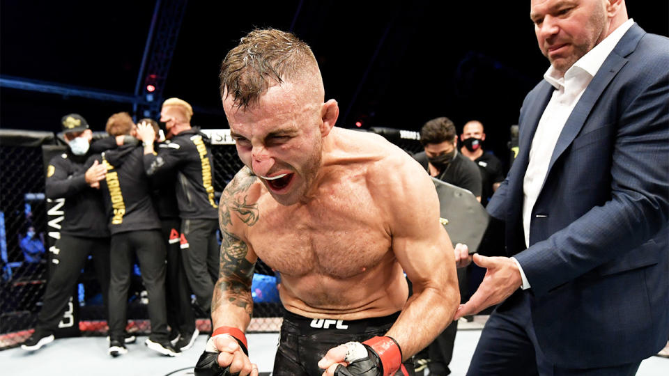 Alexander Volkanovski (pictured) cheering as Dana White (pictured right) places the belt around his waist.