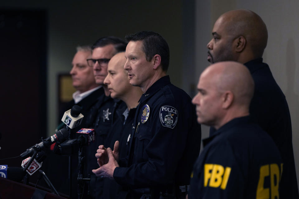 Michigan State University Interim Deputy Police Chief Chris Rozman, center, joins law enforcement officials while addressing the media, Tuesday, Feb. 14, 2023, in East Lansing, Mich. Police said a man suspected of killing several people and wounding others at the university on Monday night has died. Police said the man apparently shot himself off campus. (AP Photo/Carlos Osorio)