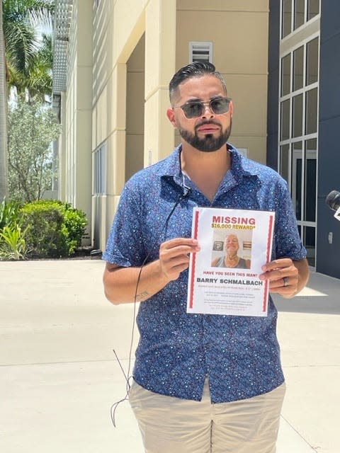 Miguel Blanco, a close friend of Barry Schmalbach, 56, holds up a missing person's sign on Friday, Aug. 4, 2023. The search for Schmalbach, who went missing July 19, 2023, is nearing two weeks.