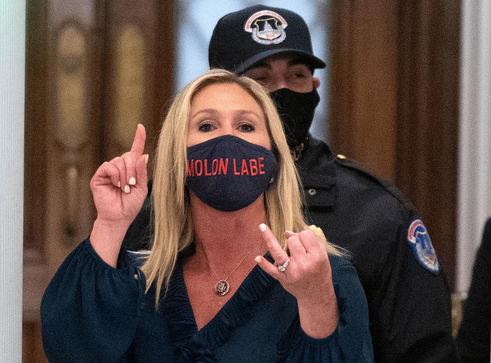 Greene shouts at journalists as she goes through security inside the U.S. Capitol on her way to the House of Representatives. She wore a face mask emblazoned the words "Molon Labe," an ancient Greek phrase meaning "Come and take them," a common refrain among gun rights extremists. (Photo: ANDREW CABALLERO-REYNOLDS via Getty Images)