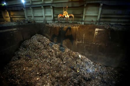 FILE PHOTO: A clamshell shovel prepares to carry kitchen waste at a garbage incineration plant on the outskirts of Beijing, China March 30, 2017. Picture taken on March 30, 2017. REUTERS/Jason Lee