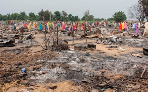 Women sift through the remains of a market blown up during an attack on September 20, 2018, in Amarwa - Credit: AUDU MARTE/ AFP