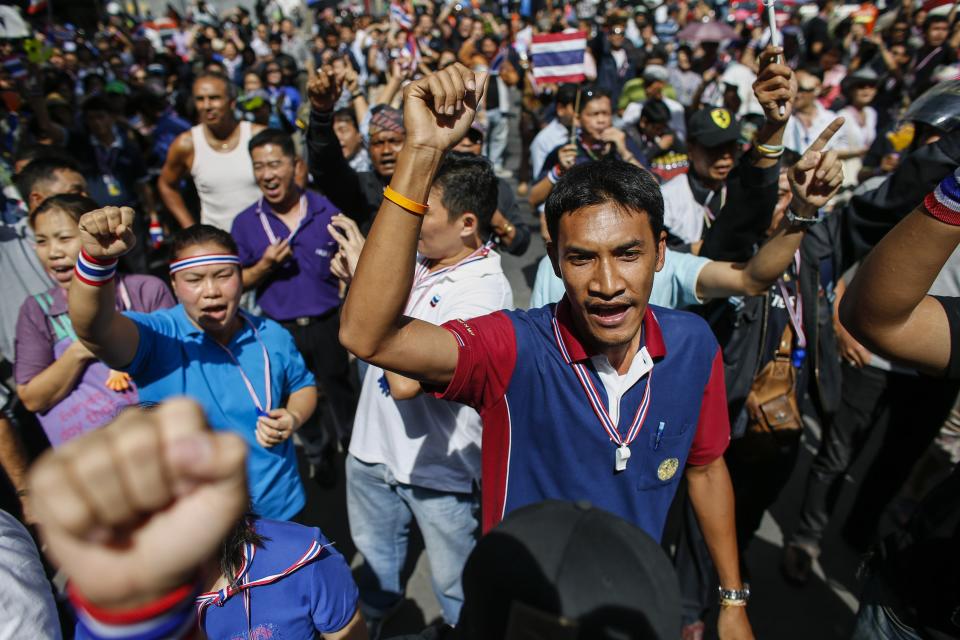 Anti-government protesters shout slogans as they gather outside the headquarters of the ruling Puea Thai Party of Prime Minister Yingluck Shinawatra in Bangkok