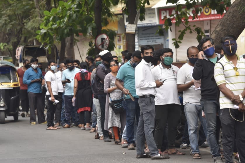 People wait in queues outside the office of the Chemists Association to demand necessary supply of the anti-viral drug Remdesivir, in Pune, India, Thursday, April 8, 2021. India is experiencing its worst pandemic surge, with a seven-day rolling average of more than 130,000 cases per day. Hospitals across the country are starting to get overwhelmed with patients, and experts worry the worst is yet to come. (AP Photo)