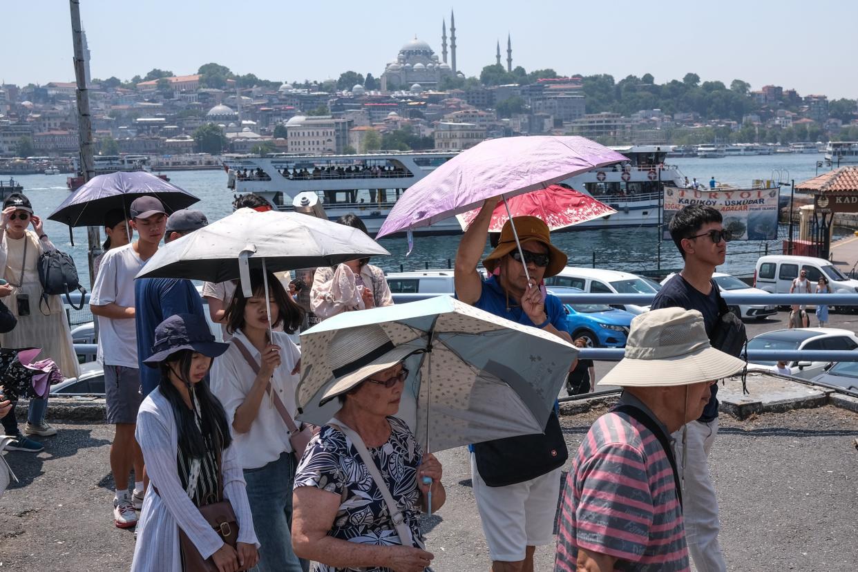 Tourists walk with umbrellas in Istanbul, Turkey (EPA)