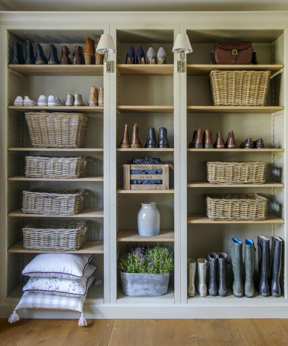 A hallway shoe storage idea with a wall of shelving