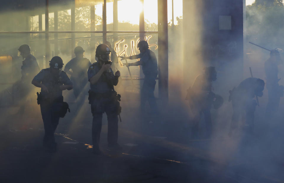 Police move through an area during demonstrations Thursday, May 28, 2020, in St. Paul, Minn. Protests over the death of George Floyd, the black man who died in police custody broke out in Minneapolis for a third straight night. (AP Photo/Julio Cortez)