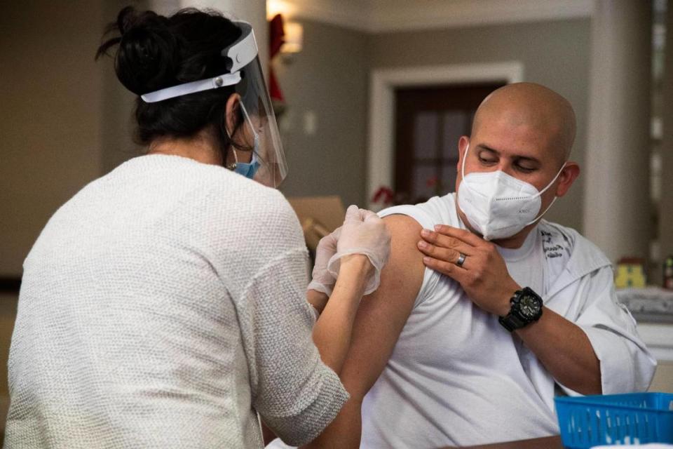 Julio Cera, executive chef at Wellmore of Lexington, receives the first shot of the coronavirus vaccine at Wellmore of Lexington on Wednesday, December 30, 2020. While dining services has instituted safety measures, Cera is happy to receive additional protection.