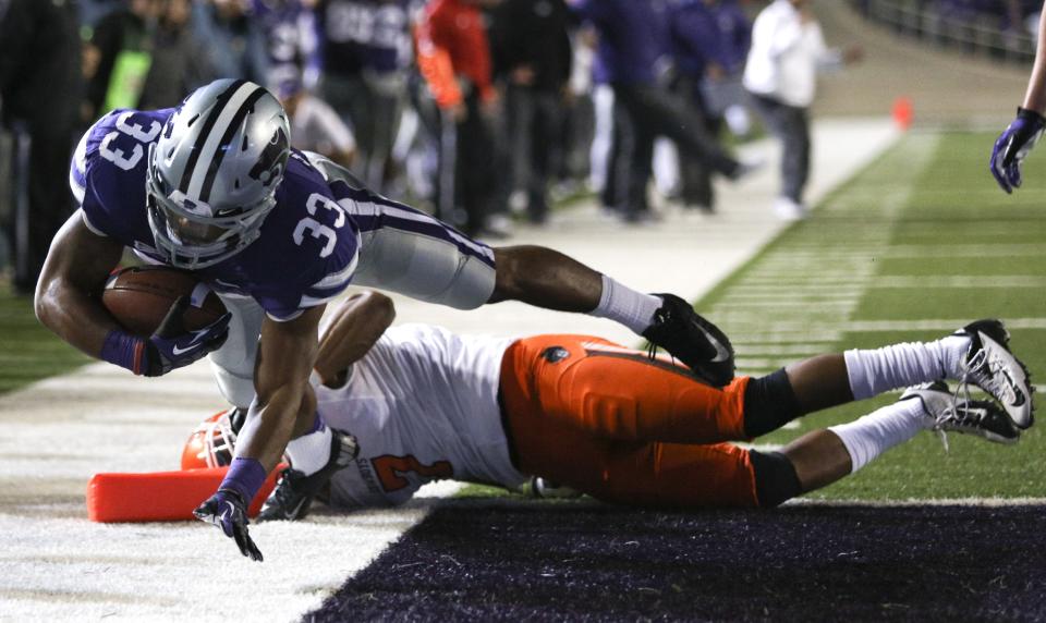 Running back John Hubert #33 of the Kansas State Wildcats leaps into the end zone for a touchdown over Shamiel Gary #7 of the Oklahoma State Cowboys in first quarter at Bill Snyder Family Football Stadium on November 3, 2012 in Manhattan, Kansas. (Photo by Ed Zurga/Getty Images)