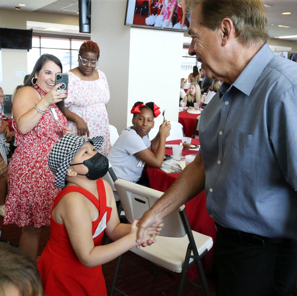 Alabama head coach Nick Saban works his way through the crowd, greeting, signing autographs and having photos taken during the Nick's Kids Foundation luncheon Wednesday Aug. 2, 2023, in Bryant-Denny Stadium. Ali Plowman shakes hands with Saban.