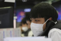 A currency trader talks on the phone at the foreign exchange trading room of the KEB Hana Bank headquarters in Seoul, South Korea, Tuesday, Feb. 4, 2020. Shares advanced in Asia on Tuesday, with the Shanghai Composite up 0.2% after a rebound on Wall Street overnight. (AP Photo/Ahn Young-joon)