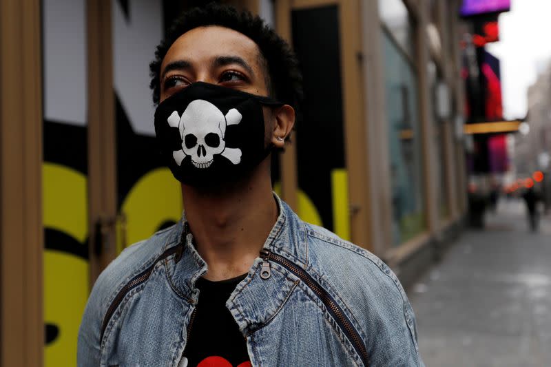 FILE PHOTO: A man wears a protective mask decorated with skull and crossbones design as he walks in midtown Manhattan during the coronavirus outbreak in New York