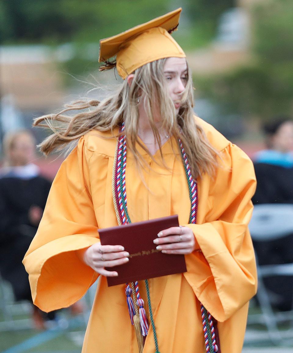 Paige Dwyer walks in the wind with her diploma during Weymouth High's graduation on Saturday, June 3, 2023.