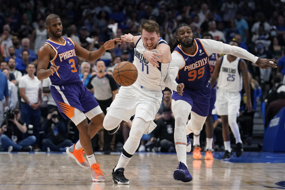 Dallas Mavericks guard Luka Doncic (77) battles Phoenix Suns forward Jae Crowder (99) and guard Chris Paul (3) for a loose ball during the second half of Game 3 of an NBA basketball second-round playoff series, Friday, May 6, 2022, in Dallas. (AP Photo/Tony Gutierrez)