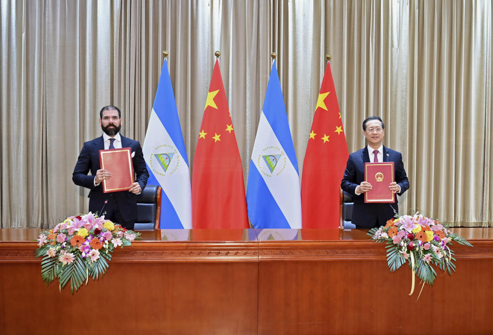 In this photo released by China’s Xinhua News Agency, representatives Laureano Ortega Murillo, son of and advisor to Nicaraguan President Daniel Ortega, left, and Chinese Vice Foreign Minister Ma Zhaoxu display their jointly signed communique on the resumption of diplomatic relations between the two countries in northern China’s Tianjin Municipality, Friday, Dec. 10, 2021. Taiwan lost Nicaragua as a diplomatic ally after the Central American country said it would officially recognize only China, which claims self-ruled Taiwan as part of its territory. (Yue Yuewei/Xinhua via AP)