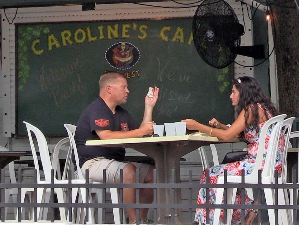 A couple dines at Caroline’s Cafe on Duval Street in Key West, Florida, May 4, 2020. The city allowed restaurants to open at 25% capacity.