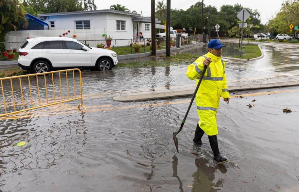 City of Miami Community Response Team Member Eddy Hernandez uses a shovel to scoop debris from a drain at the Bay of Pigs Memorial Park on Wednesday, April 12, 2023, in Miami, Fla.
