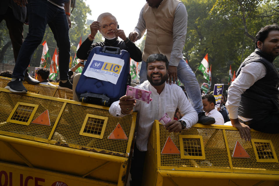 Members of opposition Congress party, demanding an investigation into allegations of fraud and stock manipulation by India's Adani Group shout slogans atop a police barricade during a protest in New Delhi, India, Monday, Feb.6, 2023. The Congress party urged people to protest, adding to pressure on Prime Minister Narendra Modi to respond to a massive sell-off of shares in Adani Group companies after a U.S.-based short-selling firm, Hindenburg Research, accused them of various fraudulent practices. The Adani group has denied any wrongdoing. (AP Photo/Manish Swarup)