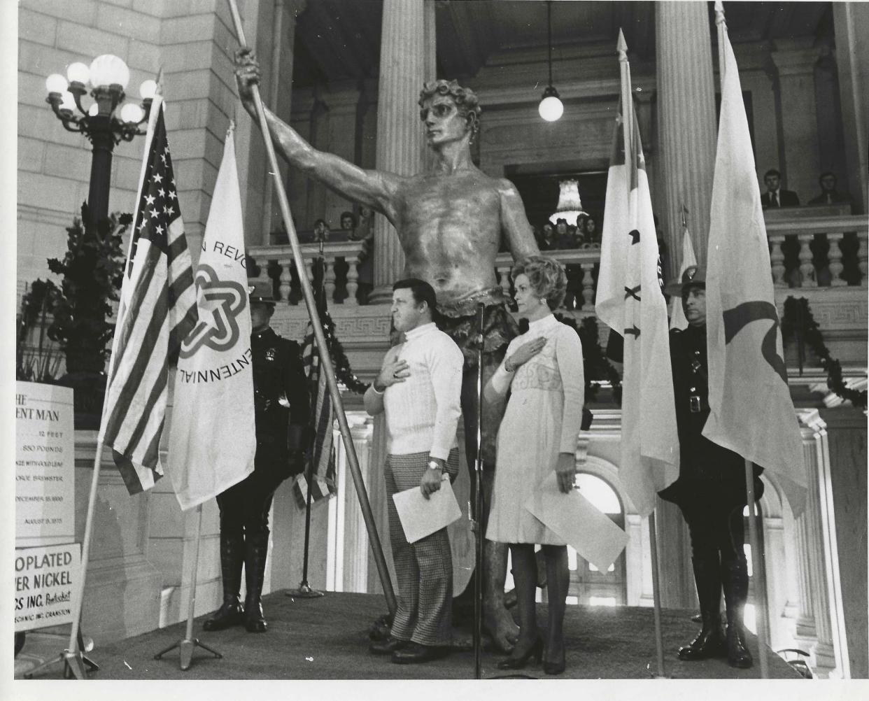 A ceremony marking the move of the Independent Man from Warwick Mall to the State House rotunda in 1976. Pat Conley, left, chairman of the Rhode Island Bicentennial of Independence Commission, and Rhode Island First Lady Joyce Anne Noel, right, presided at the event.
