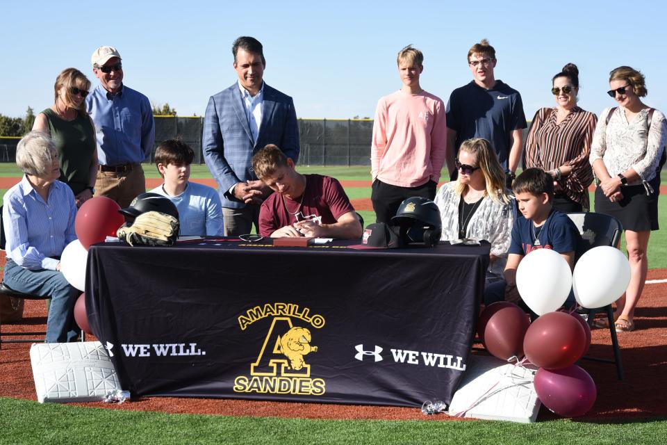 Max Milligan, center, signs his letter of commitment to Trinity University at Sandie Baseball Field on Thursday.