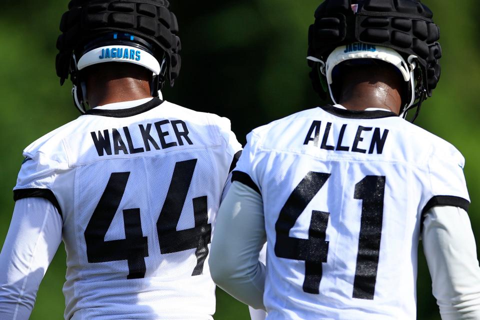 Jaguars outside linebacker Travon Walker (44) and defensive end/outside linebacker Josh Allen (41) look on during training camp.