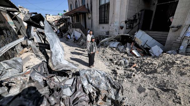 PHOTO: People stand by rubble and the remains of a destroyed vehicle outside a mosque in the occupied West Bank city of Jenin, July 5, 2023, after the Israeli army declared the end of a two-day military operation in the area. (Ahmad Gharabli/AFP via Getty Images)