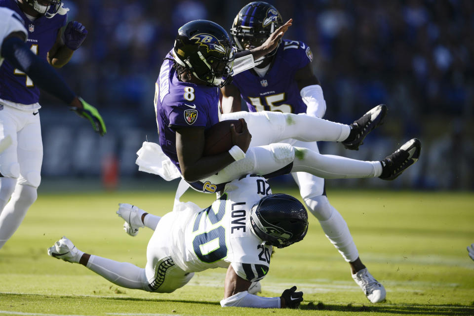 Baltimore Ravens quarterback Lamar Jackson (8) is tackled by Seattle Seahawks safety Julian Love (20) during the first half of an NFL football game, Sunday, Nov. 5, 2023, in Baltimore. (AP Photo/Nick Wass)