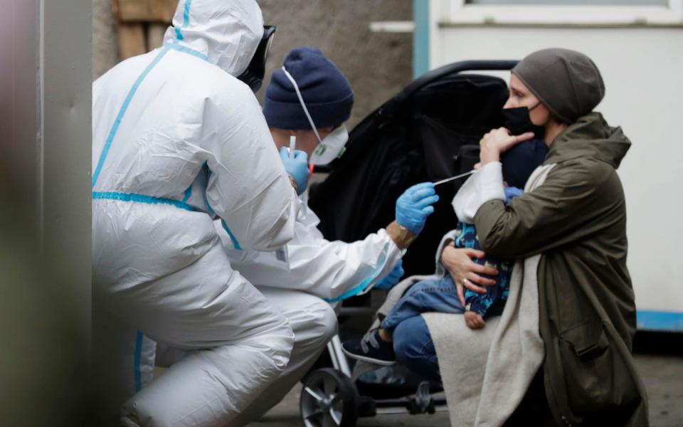 A child is tested at a coronavirus testing site at the Solec Hospital in Warsaw, Poland - AP