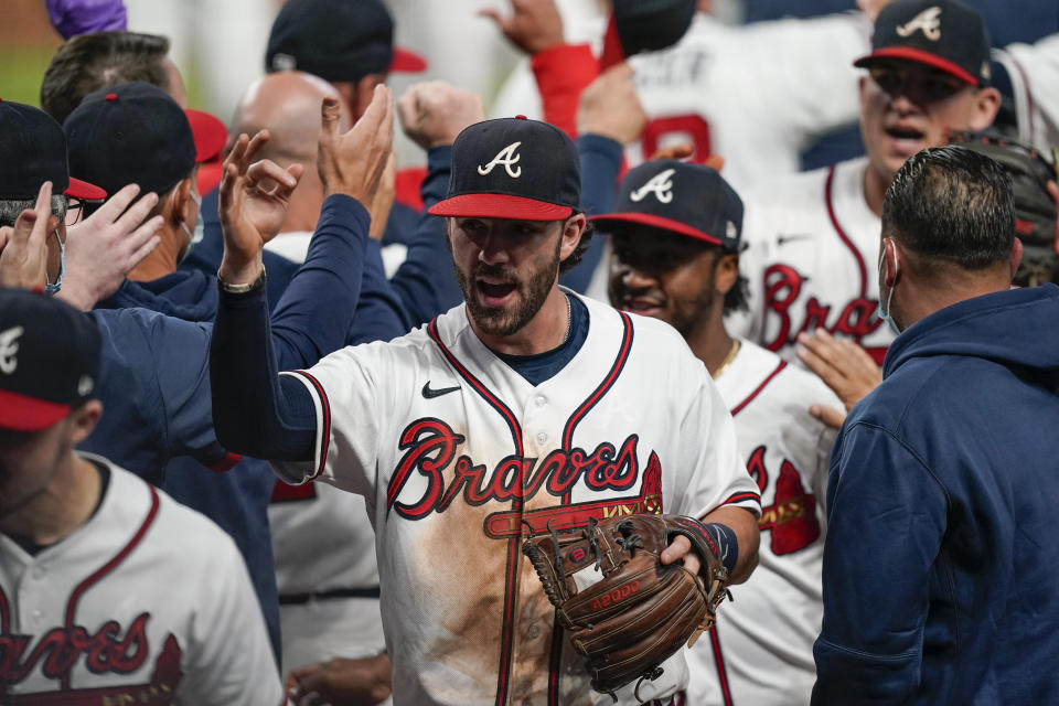 Atlanta Braves' Dansby Swanson, center, celebrates after a baseball game to clinch the NL East title against the Miami Marlins on Tuesday, Sept. 22, 2020, in Atlanta. (AP Photo/Brynn Anderson)