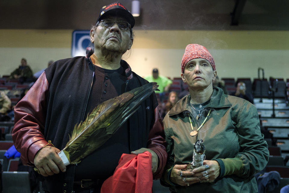 U.S. Army veterans Aloysious Bell, left, and Tie Kobolson, hold ceremonial feathers and a smudge stick during a forgiveness ceremony for veterans at the Four Prairie Knights Casino &amp; Resort on the Standing Rock Sioux Reservation on Monday.