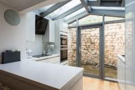 Junto al salón está la cocina, que tiene un techo estilo invernadero y un pequeño patio hundido que permite la entrada de luz. (Foto: <a href="http://www.carterjonas.co.uk/house/for-sale/grimston/yor200038/" rel="nofollow noopener" target="_blank" data-ylk="slk:Carter Jonas;elm:context_link;itc:0;sec:content-canvas" class="link ">Carter Jonas</a>).