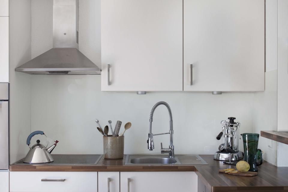 Details that might be over-designed in other kitchens—handles, sinks, countertops—were not the main focus of Talitha and Michael. They wanted this room to fade into the background of the dining and living spaces, since there are no walls between them, though they did add a few playful accents in the Michael Graves tea kettle and the La Pavoni espresso maker.