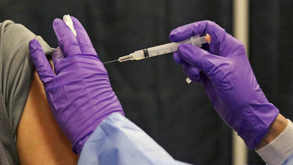 A man gets a COVID-19 vaccine at a mass vaccination site on Feb. 24, 2021, in Natick, Mass.  . (Matt Stone/The Boston Herald, Pool via AP)