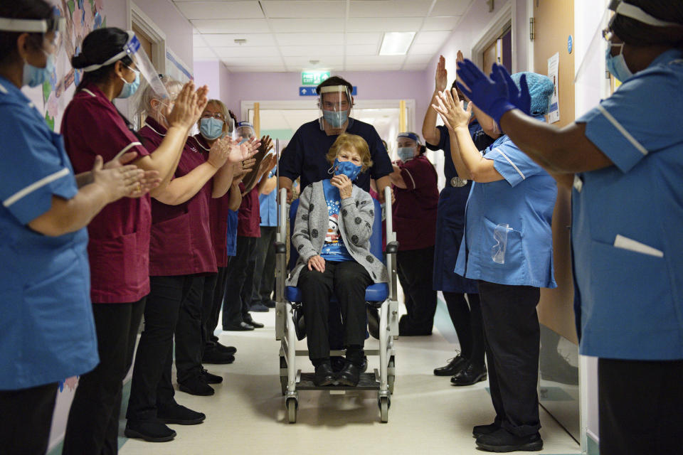 Margaret Keenan, 90, is applauded by staff as she returns to her ward after becoming the first patient in the UK to receive the Pfizer-BioNTech COVID-19 vaccine, at University Hospital, Coventry, England, Tuesday Dec. 8, 2020. The United Kingdom, one of the countries hardest hit by the coronavirus, is beginning its vaccination campaign, a key step toward eventually ending the pandemic. (Jacob King/Pool via AP)