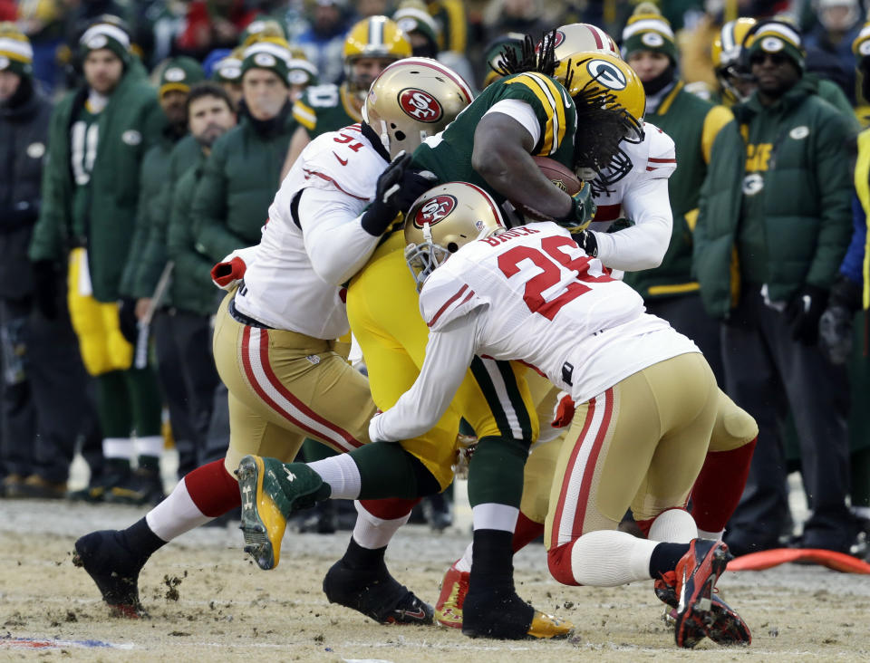 Green Bay Packers running back Eddie Lacy (27) gets tackled by San Francisco 49ers defensive end Ray McDonald (91) and cornerback Tramaine Brock (26) during the first half of an NFL wild-card playoff football game, Sunday, Jan. 5, 2014, in Green Bay, Wis. (AP Photo/Mike Roemer)