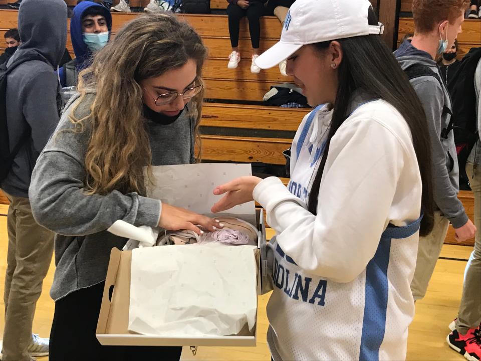 North Carolina commit Paulina Paris (right) marvels at the Michael Jordan sneakers with which her family gifted her at Saddle River Day's letter of intent signing ceremony on Wednesday, Nov. 10, 2021.
