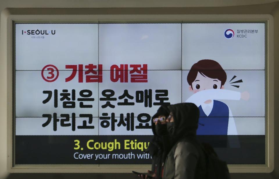 <span class="caption">On Feb. 18, 2020, in Seoul, South Korea, people wearing face masks pass an electric screen warning about COVID-19. </span> <span class="attribution"><a class="link " href="http://www.apimages.com/metadata/Index/South-Korea-China-Outbreak/cb79407a56854d69b3c3565bbc067f74/9/0" rel="nofollow noopener" target="_blank" data-ylk="slk:AP Photo/Ahn Young-joon;elm:context_link;itc:0;sec:content-canvas">AP Photo/Ahn Young-joon</a></span>