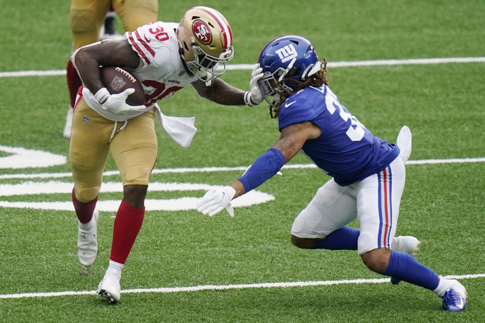 San Francisco 49ers' Jeff Wilson, left, fends off New York Giants' Ryan Lewis during the second half of an NFL football game, Sunday, Sept. 27, 2020, in East Rutherford, N.J. (AP Photo/Corey Sipkin)