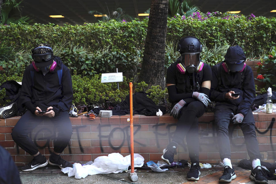 Protesters rest at Hong Kong Polytechnic University after police stormed part of the campus during the early morning hours in Hong Kong, Monday, Nov. 18, 2019. Police breached the university campus held by protesters early Monday after an all-night siege that included firing repeated barrages of tear gas and water cannons. (AP Photo/Vincent Yu)