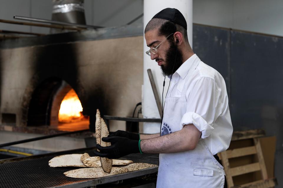 An ultra-Orthodox Jewish man prepares special matzo, a traditional handmade unleavened bread for Passover, at a bakery in Ashdod, Israel, Tuesday, April 4, 2023.