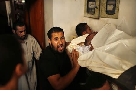 Mourners carry the body of Palestinian man Adnan Habib, who medics said was killed by Israeli shelling, during his funeral in Gaza City July 23, 2014. REUTERS/Suhaib Salem