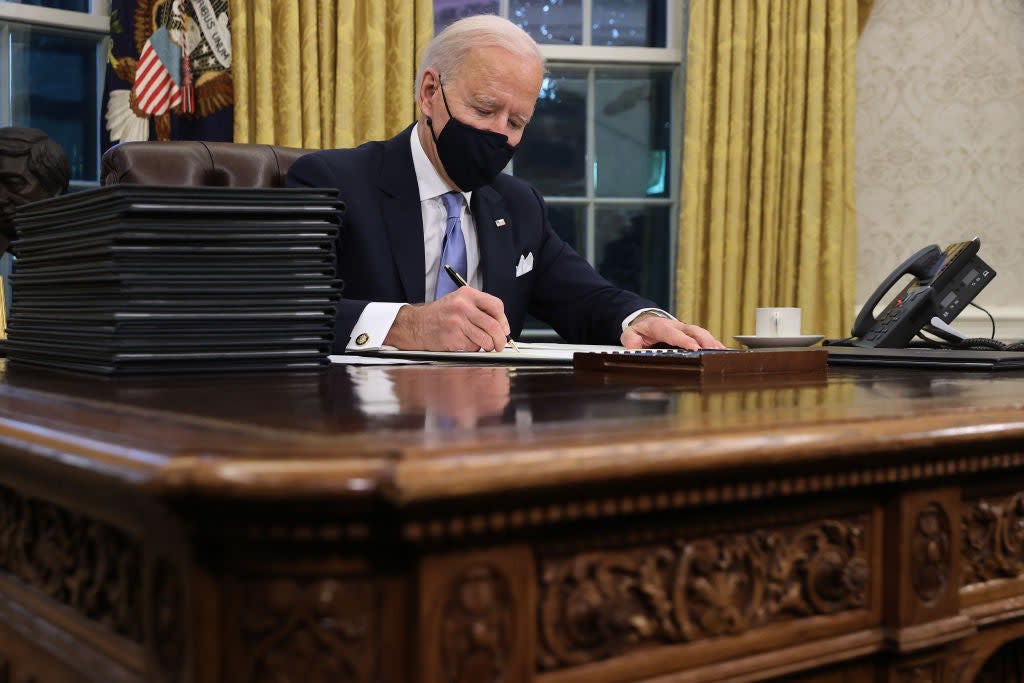 Joe Biden signs a slate of 17 executive actions hours after taking office. (Getty Images)